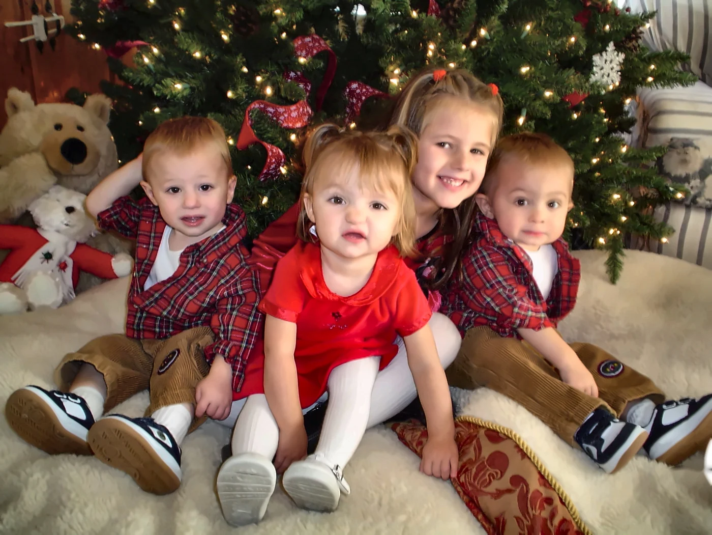 Mike Millett's four children as young kids, sitting in front of a Christmas tree: Dillon, Paige, Brooke and Carson, left to right
